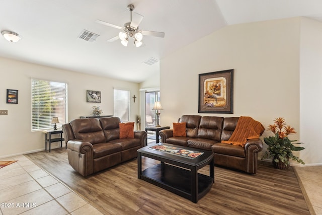 living room featuring visible vents, vaulted ceiling, and wood finished floors