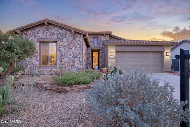 18391 W Verdin Rd, Goodyear, AZ 85338 - view of front of house featuring stone siding, a tiled roof, an attached garage, and driveway