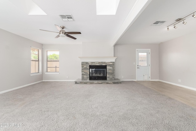 unfurnished living room featuring a skylight, visible vents, and plenty of natural light