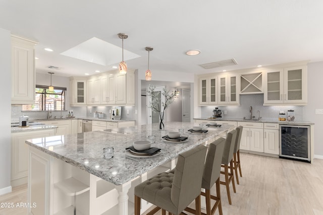 kitchen with stainless steel dishwasher, open shelves, beverage cooler, recessed lighting, and backsplash