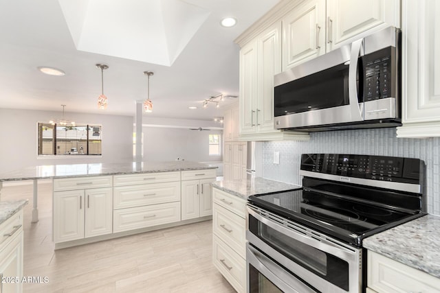 kitchen featuring recessed lighting, backsplash, appliances with stainless steel finishes, and light stone counters