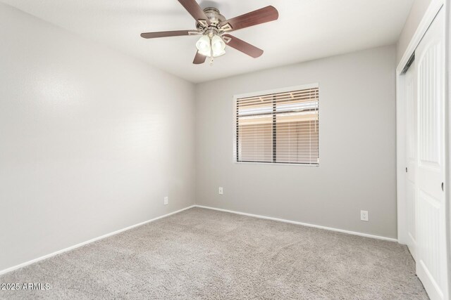 unfurnished bedroom featuring baseboards, carpet flooring, a ceiling fan, and a closet