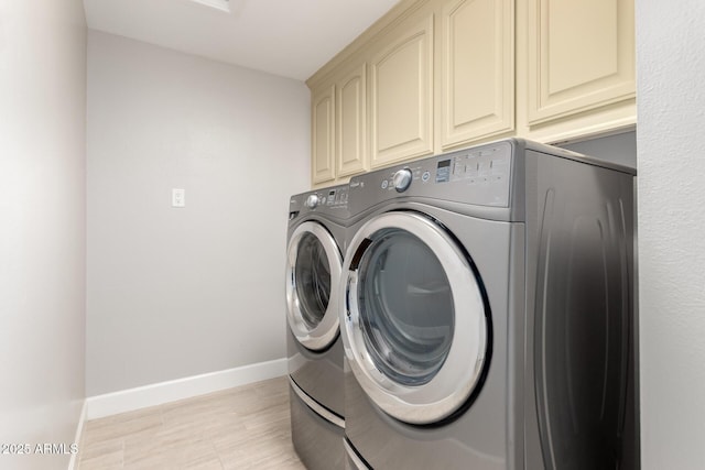 laundry room with baseboards, washer and dryer, and cabinet space