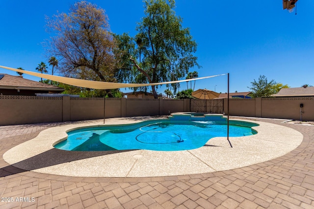 view of swimming pool featuring a fenced backyard, a pool with connected hot tub, and a patio area