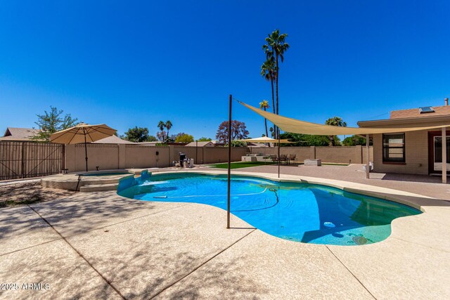 view of pool with a pool with connected hot tub, a patio, and a fenced backyard