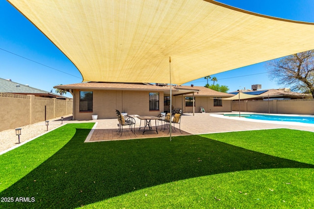 back of property featuring a fenced in pool, a yard, a patio area, and a fenced backyard