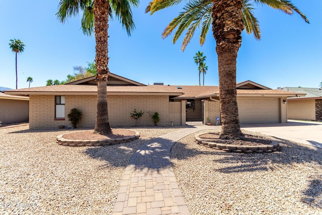 ranch-style home featuring driveway, brick siding, and a garage