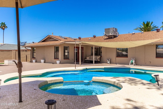 view of pool featuring a patio, fence, cooling unit, and a pool with connected hot tub