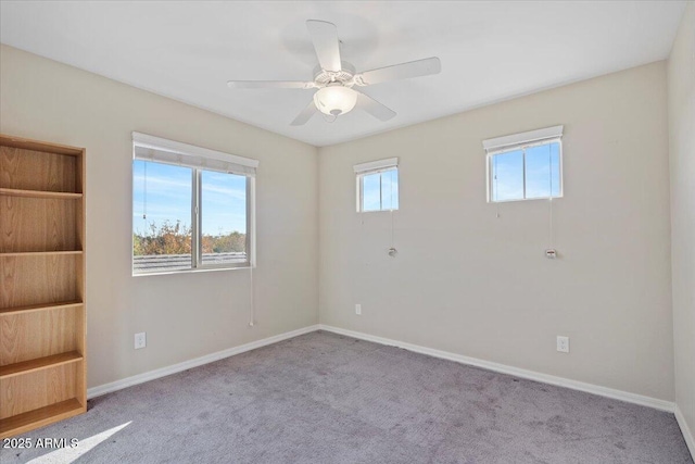 spare room featuring light colored carpet and ceiling fan