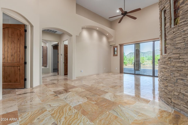 3730 E Cloud Rd, Cave Creek, AZ 85331 - spare room featuring a towering ceiling, marble finish floor, visible vents, arched walkways, and ceiling fan