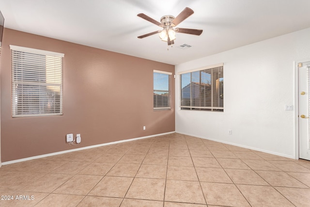 tiled spare room featuring ceiling fan