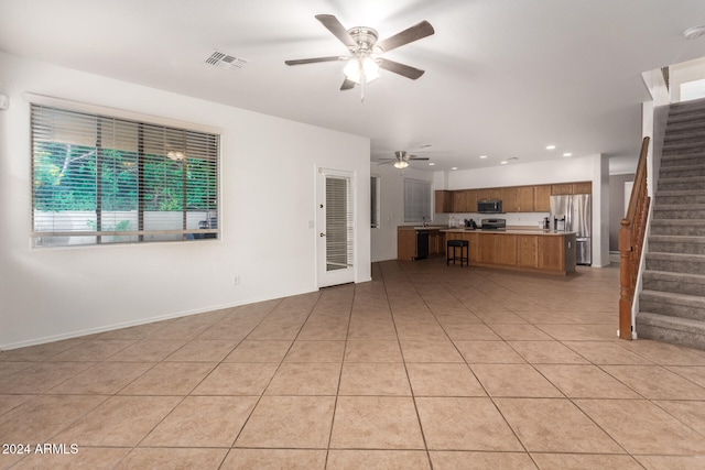 unfurnished living room featuring light tile patterned floors and ceiling fan