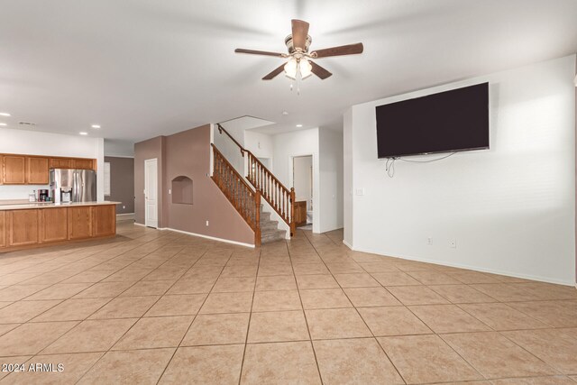 unfurnished living room featuring ceiling fan and light tile patterned floors