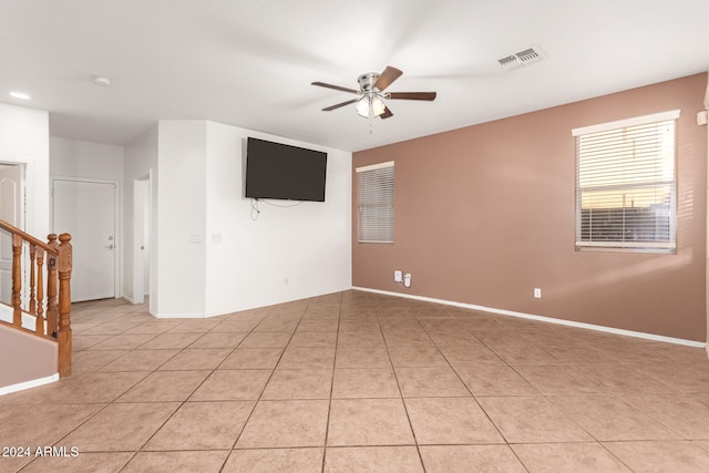 tiled empty room featuring ceiling fan