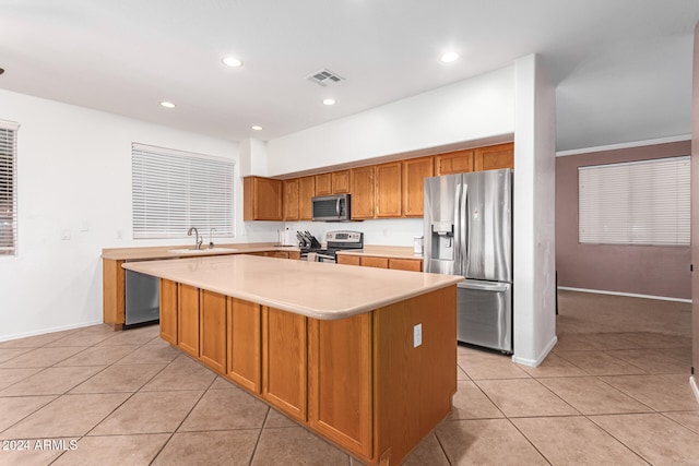 kitchen featuring a kitchen island, crown molding, light tile patterned flooring, and stainless steel appliances