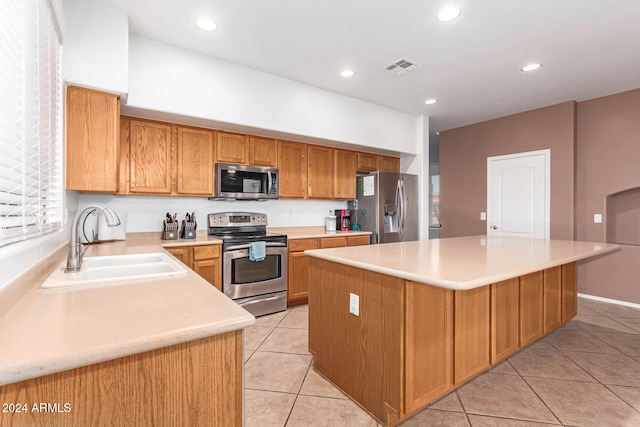 kitchen featuring stainless steel appliances, sink, a center island, and light tile patterned floors