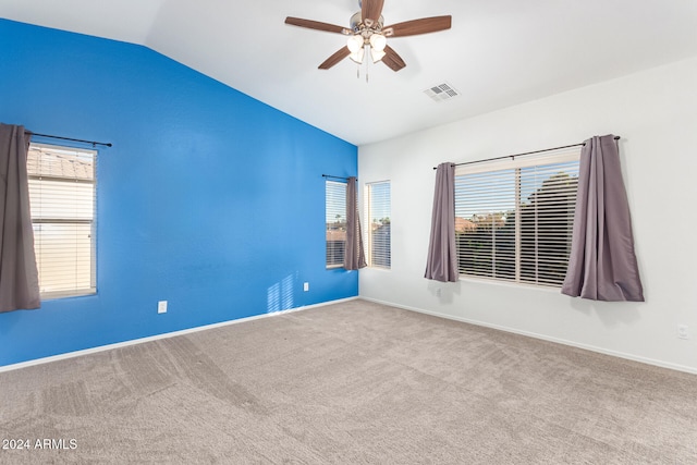 spare room featuring carpet, vaulted ceiling, and ceiling fan