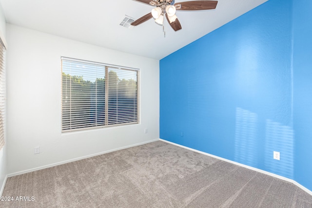 carpeted spare room with ceiling fan and vaulted ceiling