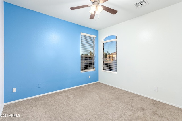 carpeted spare room featuring ceiling fan