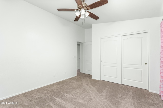 unfurnished bedroom featuring ceiling fan, a closet, and light colored carpet