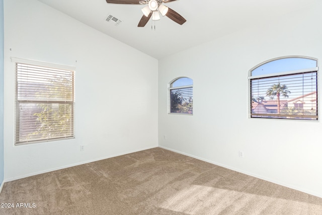 carpeted empty room featuring ceiling fan and lofted ceiling