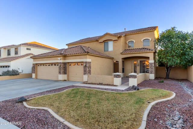 mediterranean / spanish home with a garage and a front lawn