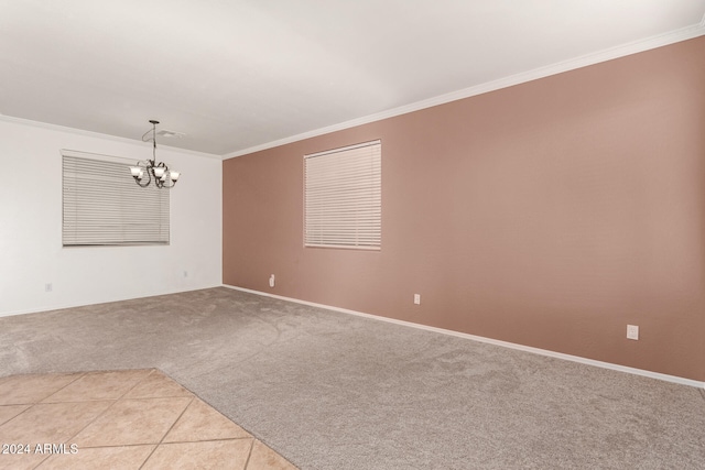 carpeted empty room with crown molding and an inviting chandelier