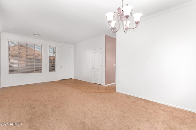 carpeted spare room featuring a chandelier and crown molding