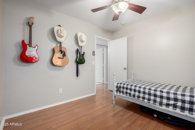 bedroom with light wood-type flooring, ceiling fan, and baseboards