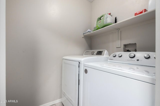 laundry area with laundry area, washer and clothes dryer, and baseboards