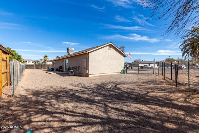 exterior space featuring central AC unit, a patio area, a fenced backyard, and stucco siding