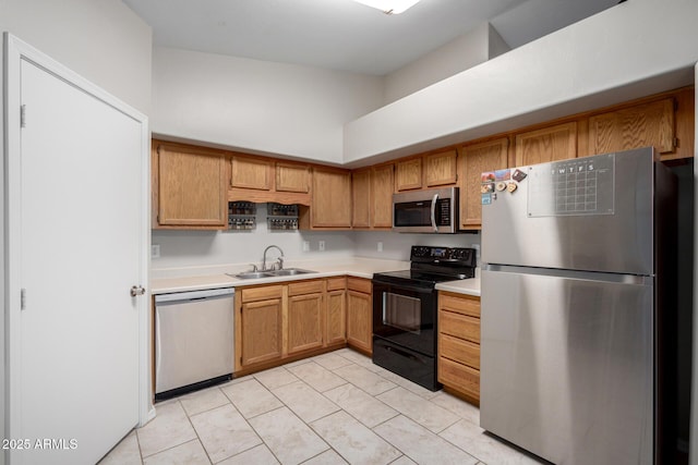 kitchen featuring stainless steel appliances, light countertops, brown cabinetry, light tile patterned flooring, and a sink