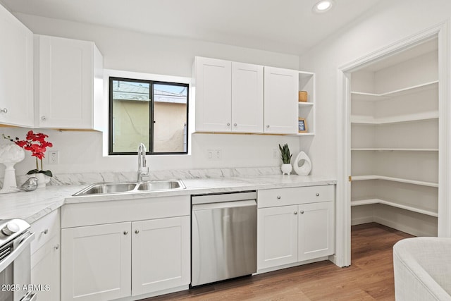 kitchen featuring dishwasher, electric stove, light wood-style floors, white cabinets, and a sink