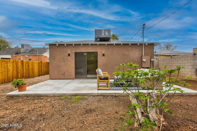 back of property featuring cooling unit, a patio area, a fenced backyard, and stucco siding