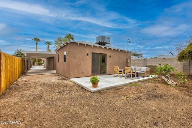 rear view of house with stucco siding, a patio, fence, outdoor lounge area, and central AC unit