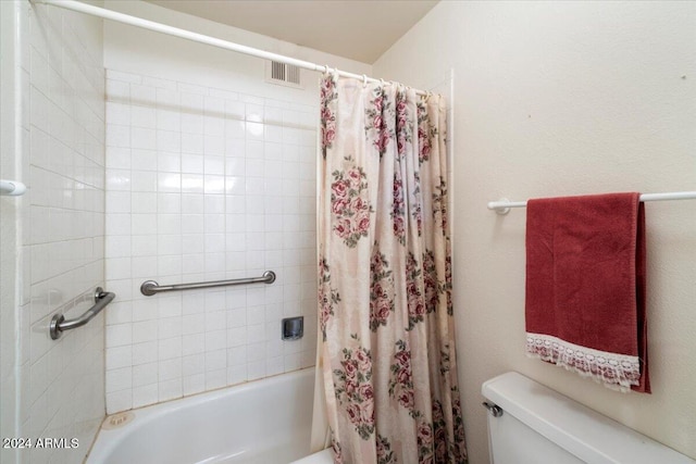 bathroom with shower / tub combo with curtain and toilet