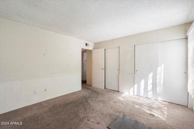 unfurnished bedroom with a textured ceiling and carpet floors