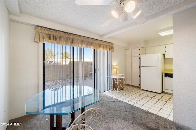 unfurnished dining area with ceiling fan, a textured ceiling, and light tile patterned floors