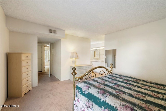 bedroom featuring a textured ceiling and light colored carpet