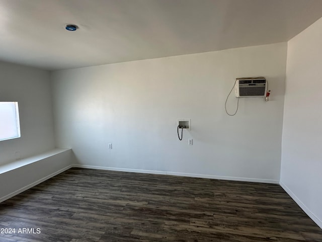 laundry area featuring an AC wall unit, hookup for a washing machine, and dark hardwood / wood-style flooring