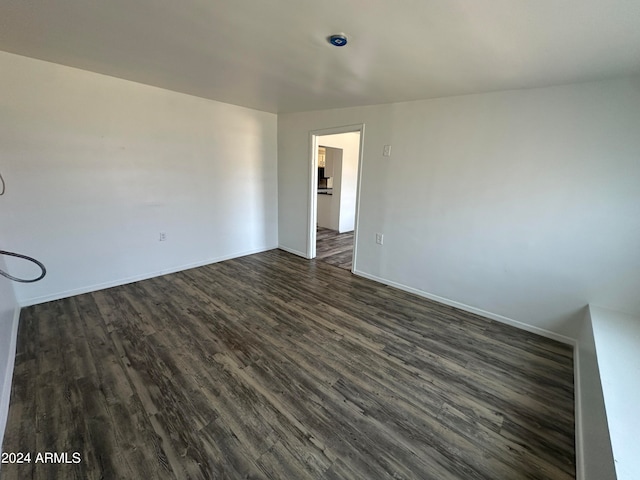 unfurnished room with dark wood-type flooring