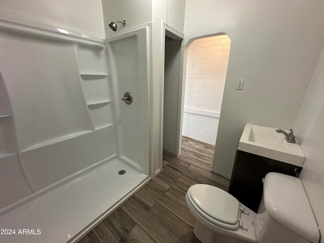 bathroom with a shower, hardwood / wood-style flooring, vanity, and toilet