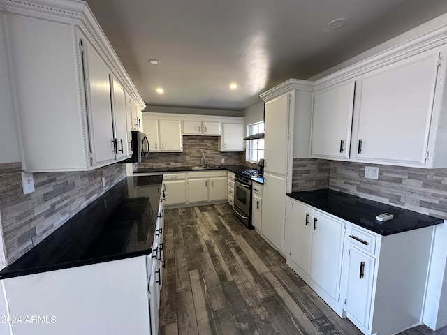 kitchen with appliances with stainless steel finishes, decorative backsplash, white cabinetry, dark wood-type flooring, and sink