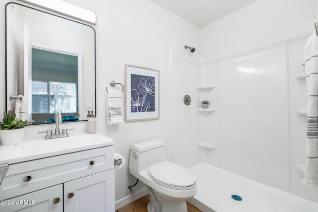 bathroom featuring a shower, hardwood / wood-style floors, vanity, and toilet