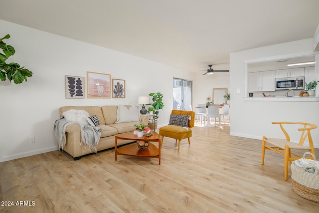 living room featuring ceiling fan and light wood-type flooring