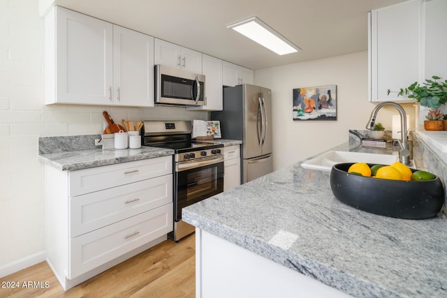 kitchen featuring light hardwood / wood-style floors, white cabinetry, sink, and appliances with stainless steel finishes