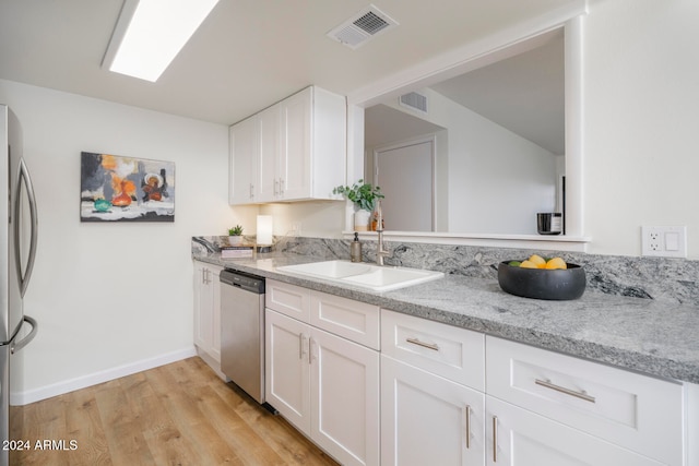 kitchen with stainless steel appliances, light hardwood / wood-style flooring, white cabinetry, and sink