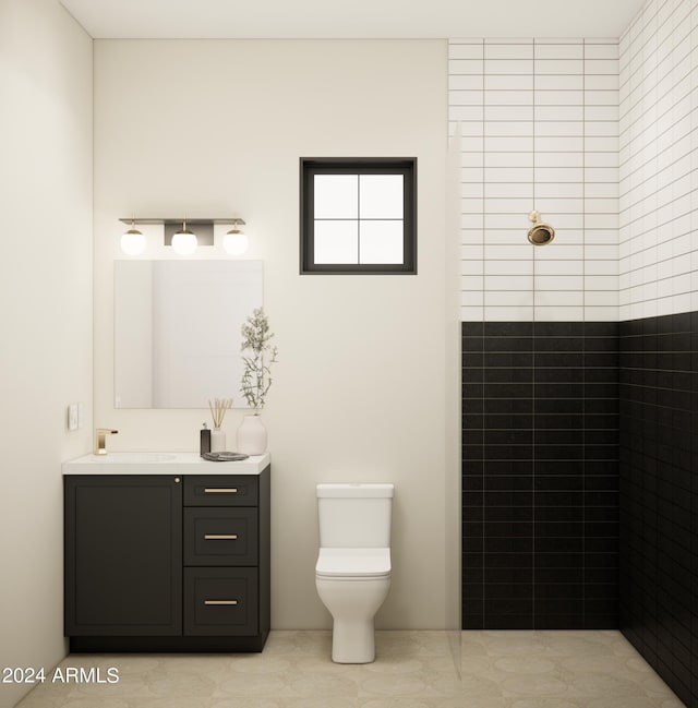 bathroom featuring tile patterned flooring, a tile shower, vanity, and toilet