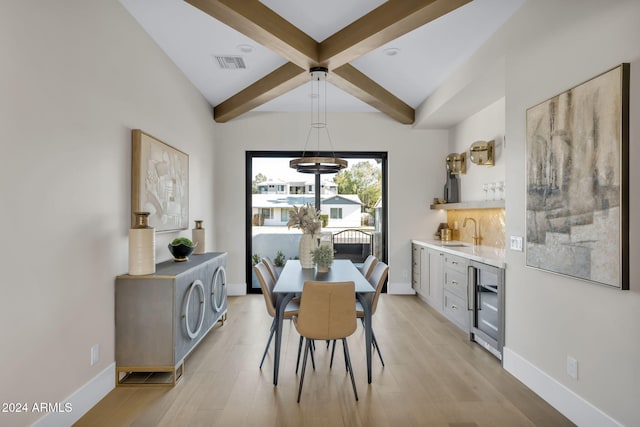 dining area featuring beamed ceiling, wine cooler, light hardwood / wood-style flooring, and sink