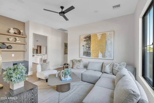 living room featuring ceiling fan, plenty of natural light, and light hardwood / wood-style flooring